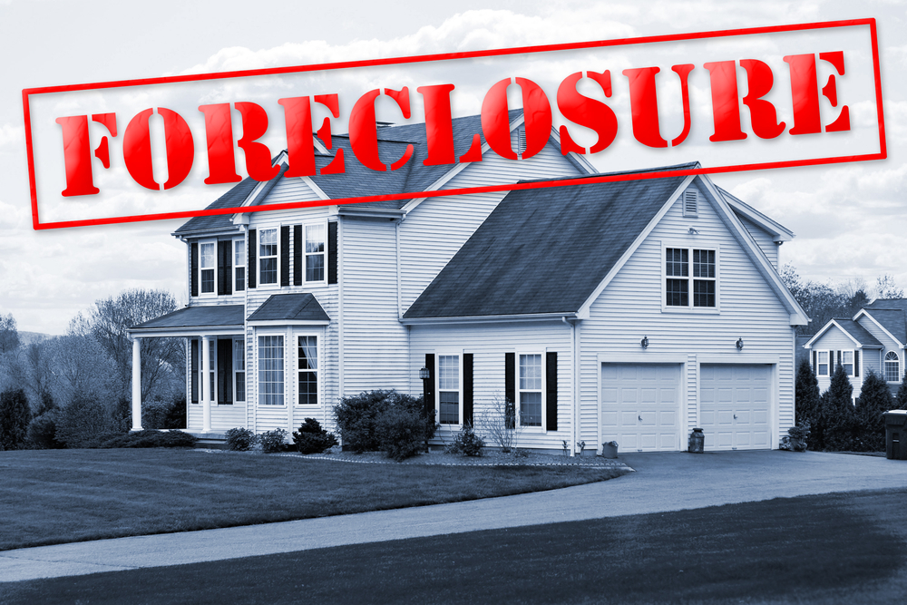 Suburban house with a large red "FORECLOSURE" stamp across the image, indicating the property is in foreclosure status