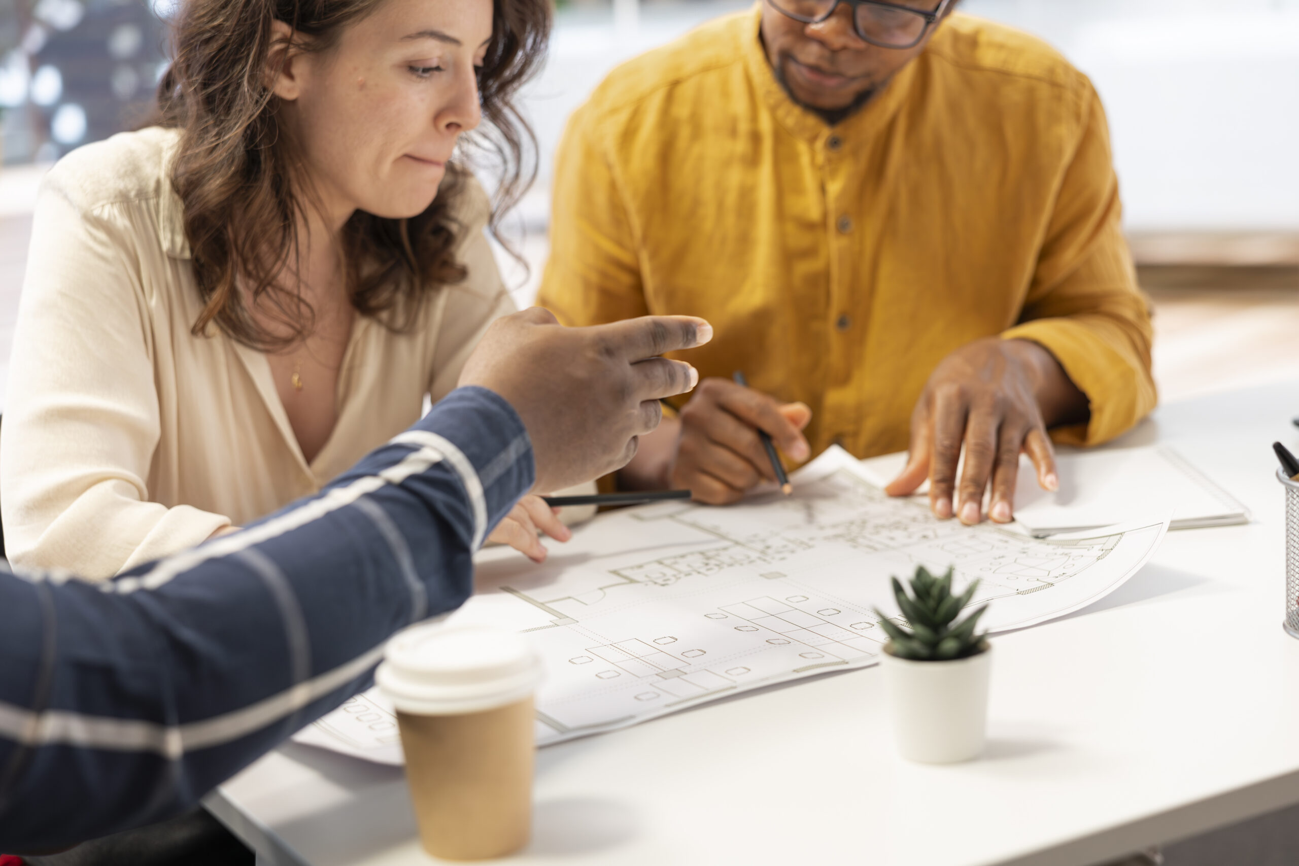 A contractor reviewing building plans with homeowners during a pre-construction meeting.